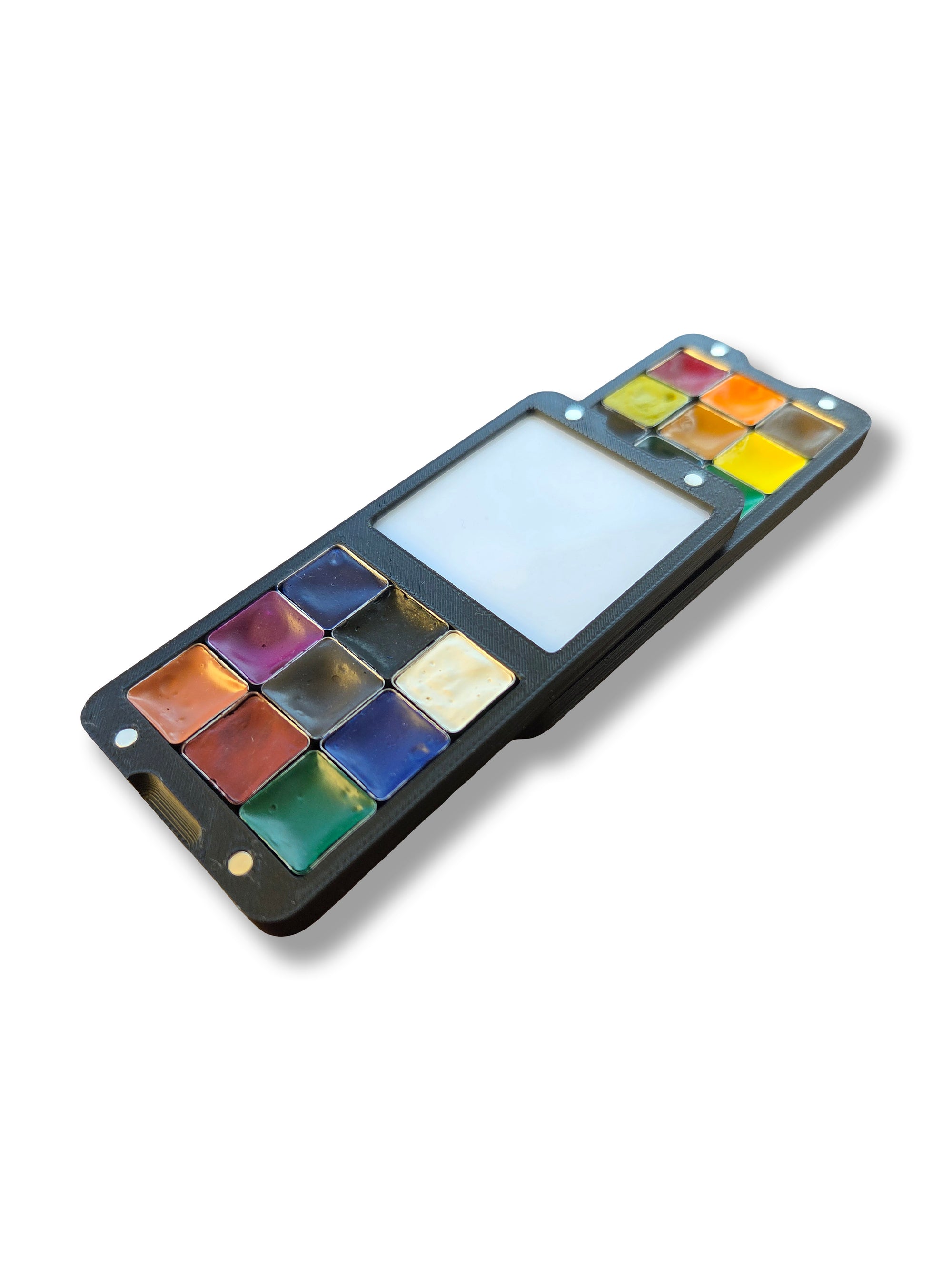 Two halves of an Arwil Art and Design Classic palette stacked, on a white background, watercolour paint pans full